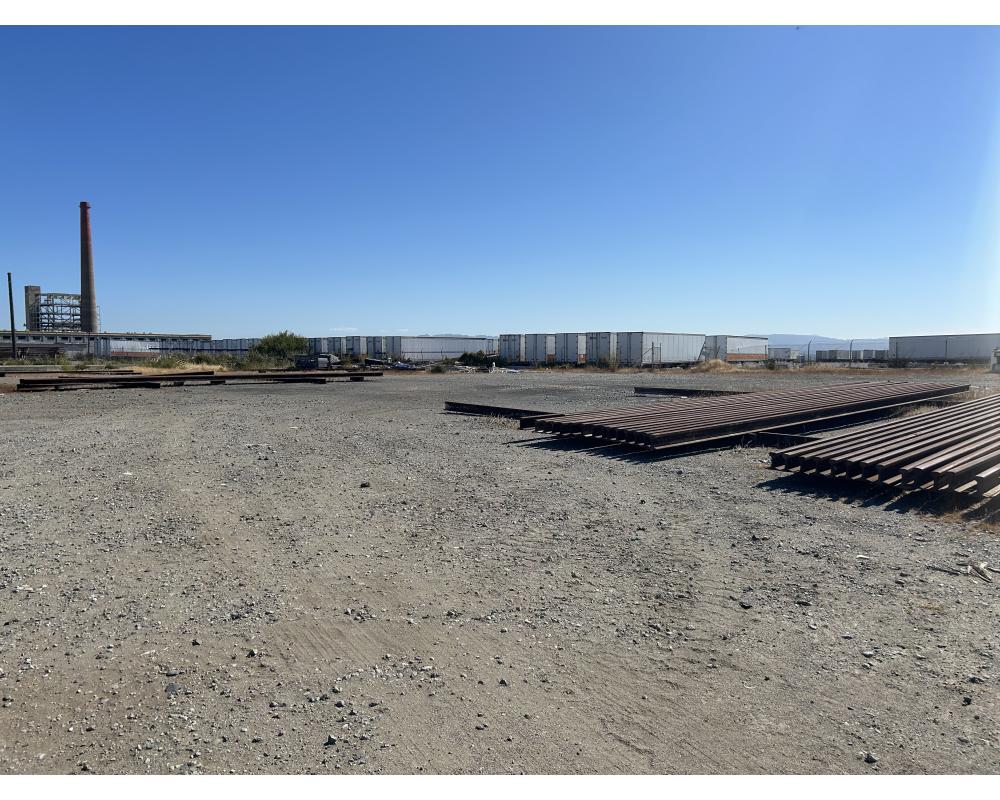 The four acre gravel storage lot adjacent to the Muni Metro East facility with the rail spikes that are currently being stored there.