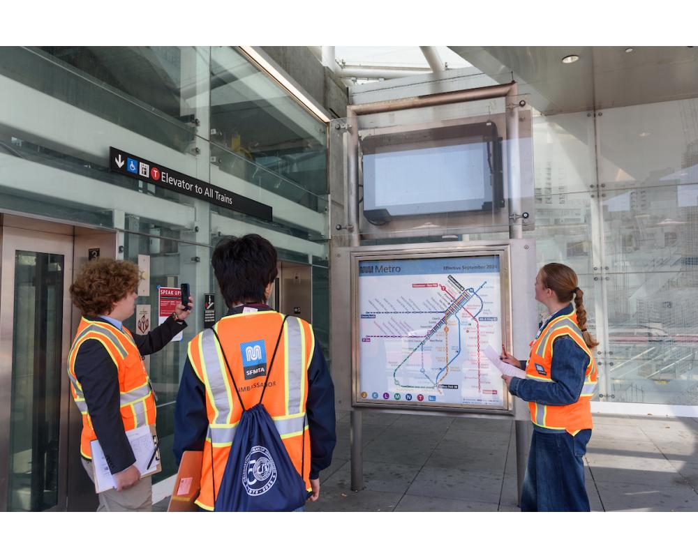 Interns performing site assessment at subway entrance.