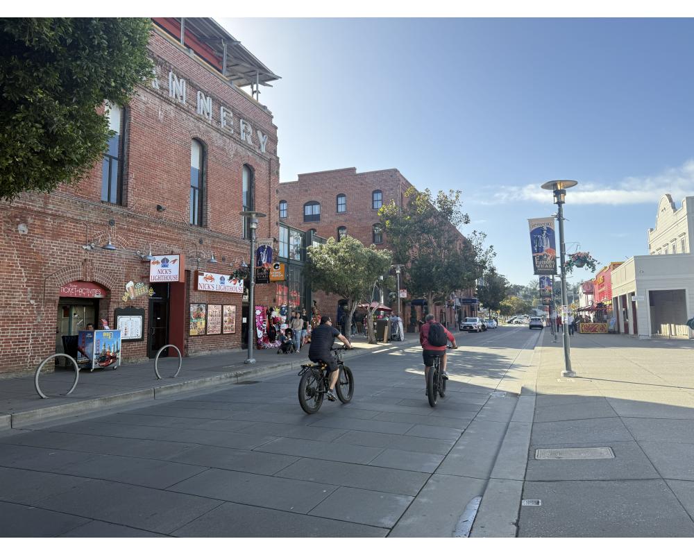 two bicyclists on Jefferson street looking west in front of the Cannery