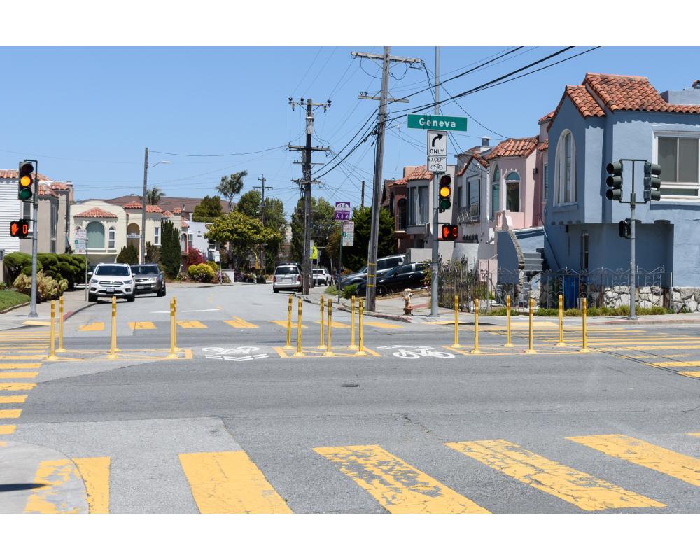 Intersection with yellow posts that prevent large vehicles from crossing through a street.