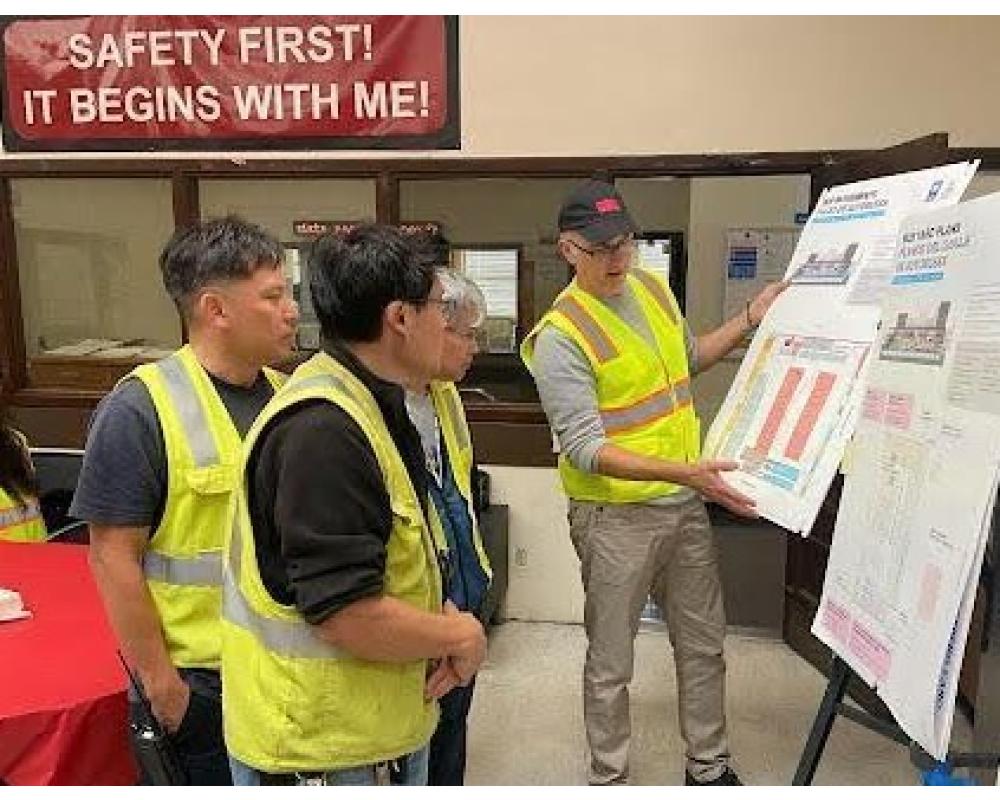 MUNI bus yard workers watching a presentation with SFMTA Staff discussing Project details