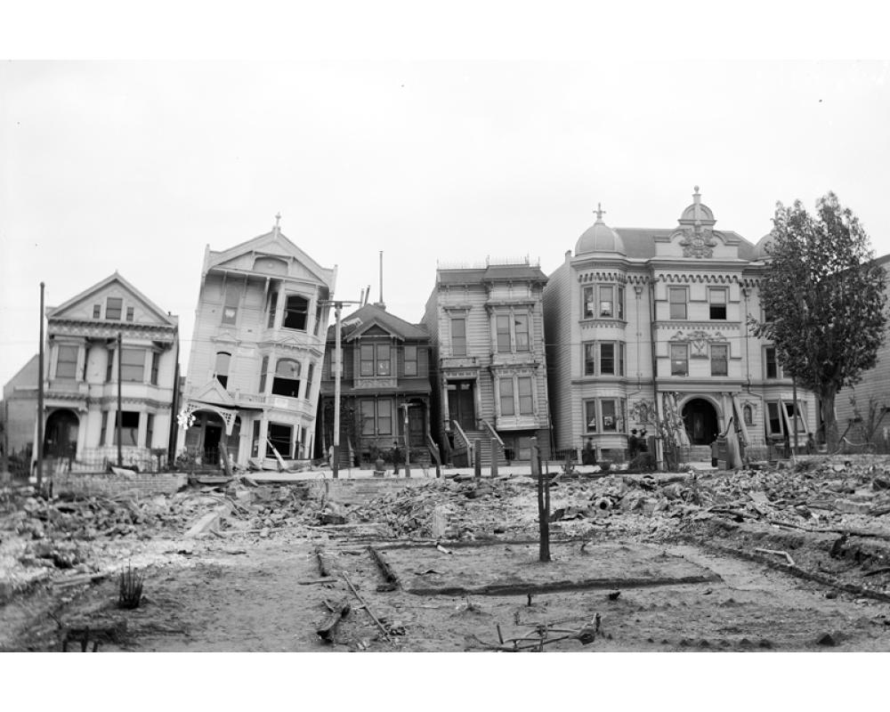 black and white photo of houses damaged and leaning after the 1906 earthquake and fire