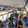 People viewing Muni Art installed in a bus.