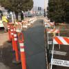 Concrete path, still wet, with construction barriers surrounding