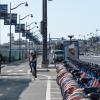 Two bicyclists in the two-way protected bikeway on Terry Francois Blvd. with a bikeshare station located in the buffer