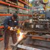 Worker welding a metal cable car frame