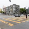 Person in the crosswalk while cars turn left from Oak Street onto Masonic Avenue