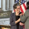 SFMTA Board of Directors Member Janet Tarlov receiving a pin at a ceremony.