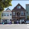 A family with children walking down a street with Victorian houses in the background.