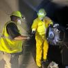 Two crew members in yellow safety equipment reroute a grease line in a Muni Metro tunnel for Fix-It Week.