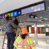 A photo of workers installing test signs at Powell Station for the Regional Mapping and Wayfinding Project.