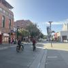 two bicyclists on Jefferson street looking west in front of the Cannery