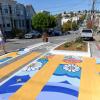 Person walks by a crosswalk that has a floral mural with multiple colors.