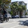 People biking on a road that has a speed hump, a raised section to slow down traffic,