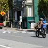 Adult and child ride on a bike toward a speed hump. 