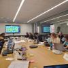 a group of people sitting at a conference table. The Working Group met the developer team in Dec 2022.