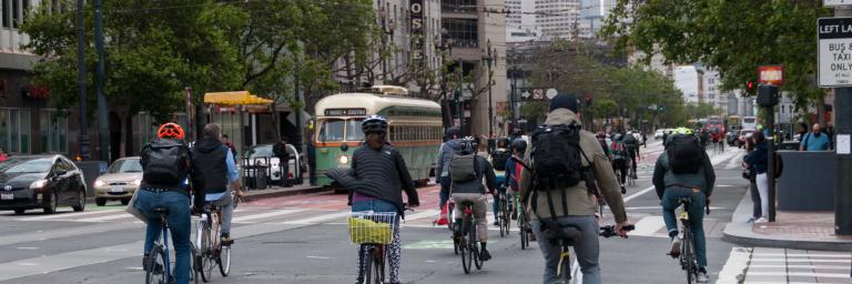 Picture of people biking on Market St crossing Van Ness Ave