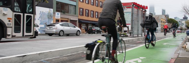 Cyclists using 7th St parking protected bicycle lane