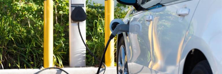 Electric vehicle plugged in to a charging station