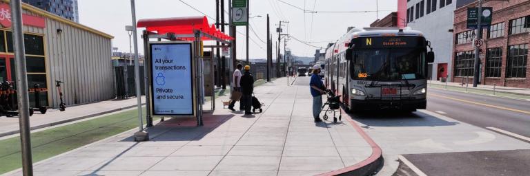 Customers boarding Muni bus on newly built sidewalk loading island on Townsend Street.