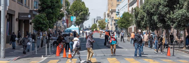 People walking across a crosswalk in the Tenderloin