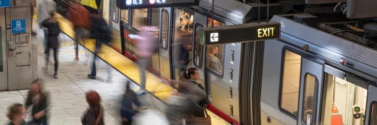 Blurred image of people loading onto train at Embarcadero Station