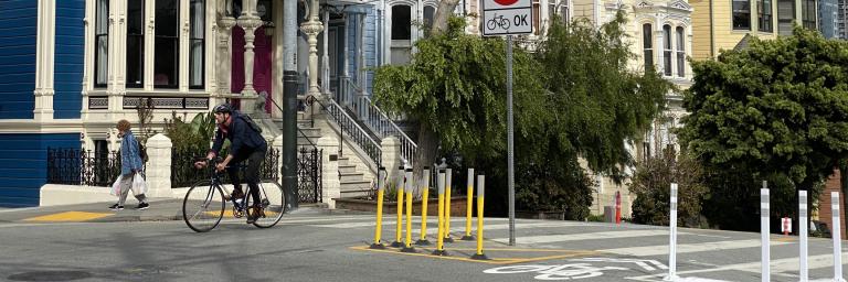 Image of a traffic diverter at Laguna Street with a bike rider and pedestrian