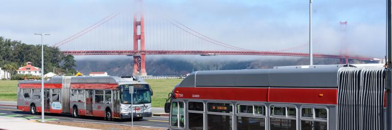 Bus stop and two coaches in the Presidio with Golden Gate Bridge in the background