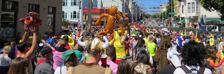 Bay to Breakers runners on with fun inflatables on Divisadero
