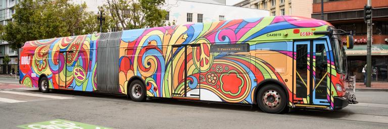 Muni 60 foot bus wrapped in psychedelic patterns 