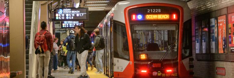 Metro train at a subway platform with people on the platform