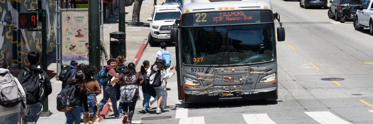 Children with back packs getting on a 22 Fillmore bus 