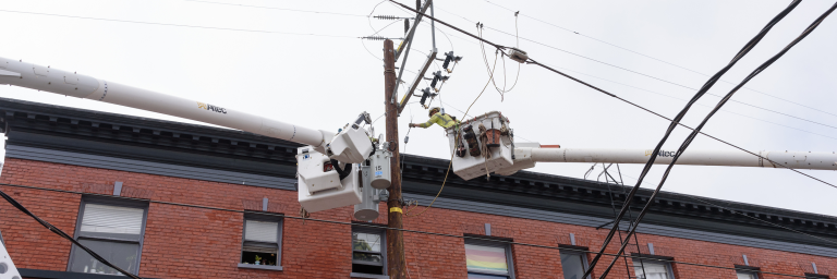 Workers suspended high above street working on Transit power systems