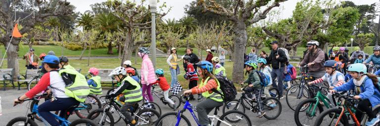 Students biking in a park during a school event.