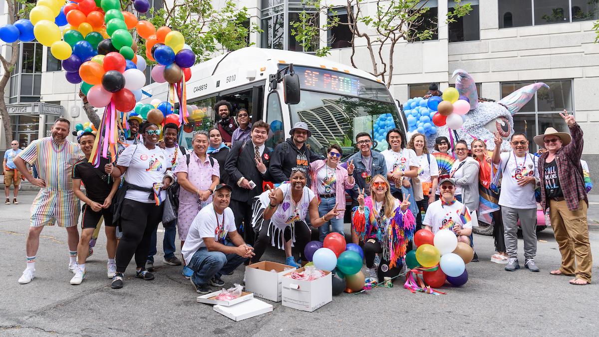 SFMTA staff, family and friends gather for a photo in front of a Muni bus at the SF Pride Parade. SFMTA staff, family and friends gather for a photo in front of a Muni bus at the SF Pride Parade.