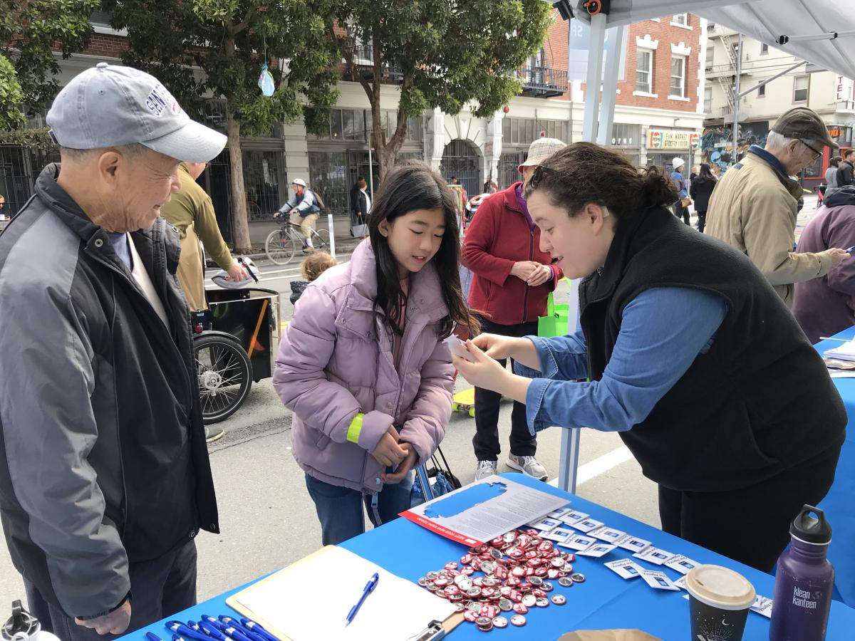 SFMTA staff showing event attendees a paper train SFMTA staff showing event attendees a paper train