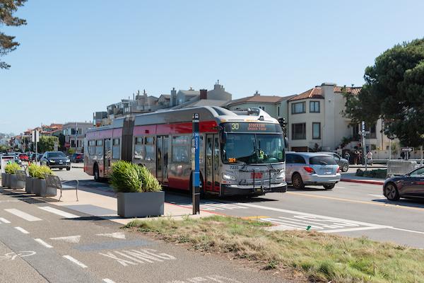 30 Stockton bus drives by a stretch of planter boxes near an intersection. 30 Stockton bus drives by a stretch of planter boxes near an intersection.