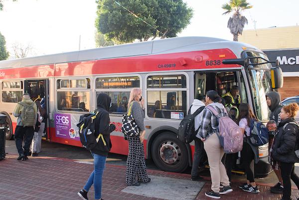 People stand in line to board the 48 Quintara at 24th and Mission streets. People stand in line to board the 48 Quintara at 24th and Mission streets.