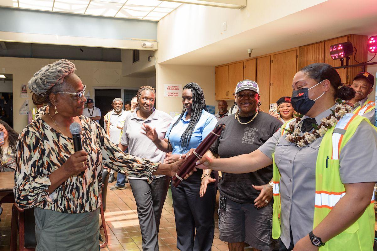 A photograph of Fannie Mae Barnes, Muni’s first gripwoman, presenting cable car grip covers to Annie Washington at a Muni cable car grip certification ceremony on May 10, 2024.