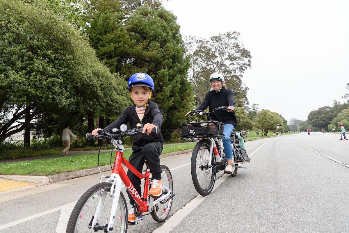 A woman and child ride their bikes in Golden Gate Park.