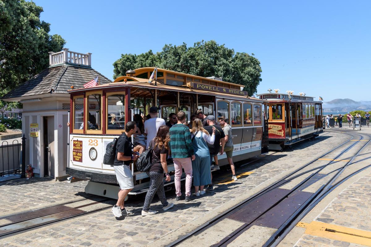 Several people board a cable car near Fisherman's Wharf.