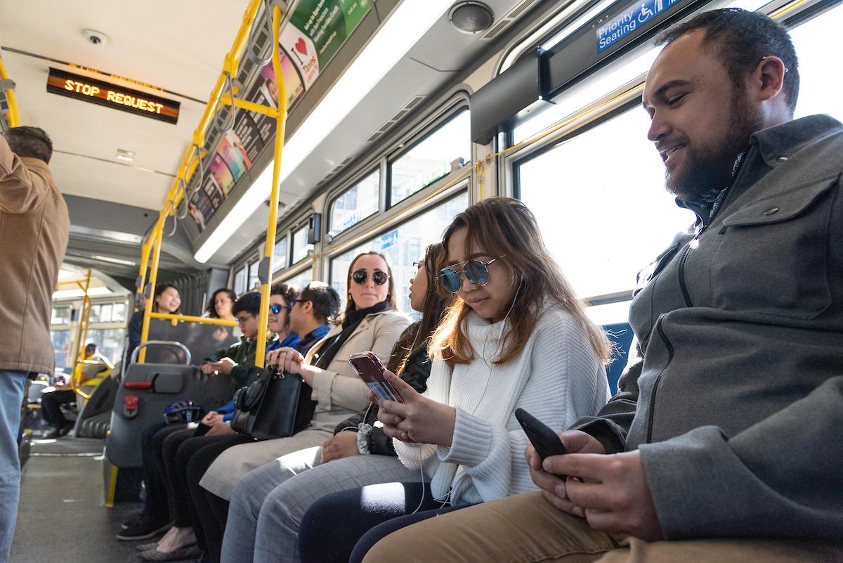People using cell phones on a train.