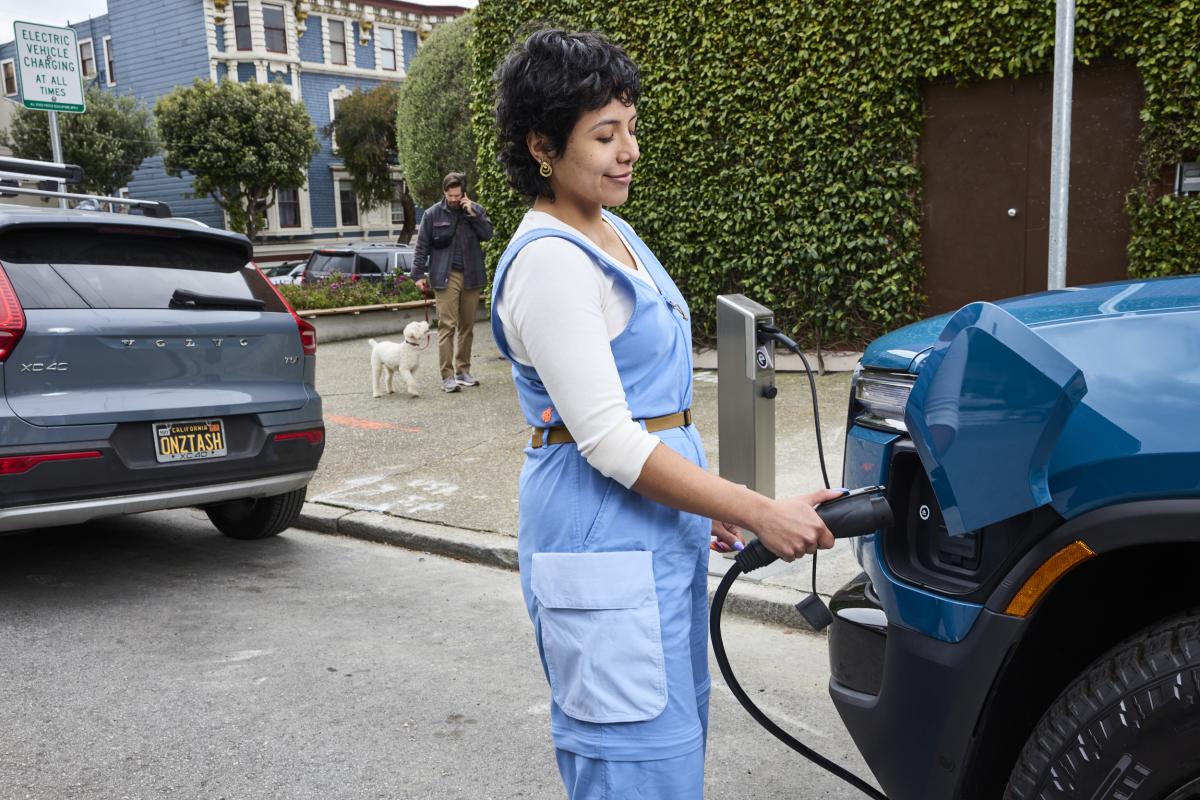 Person charging an electric vehicle at one of the two new curbside EV charging stations in Duboce Triangle.