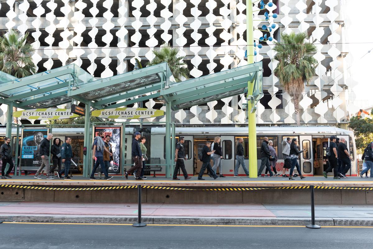 People walking on the UCSF/Chase Center Muni Metro platform, outside the Chase Center in San Francisco.