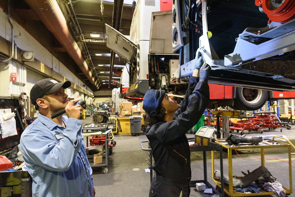 SFMTA maintenance team member trains a student intern on a maintenance task.