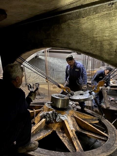 Crew prepares to lift sheave out for rehabilitation in the cable car barn basement.