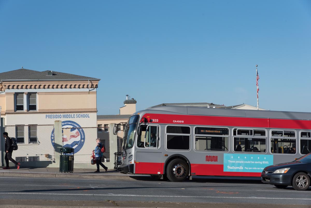 A bus in front of a school building.
