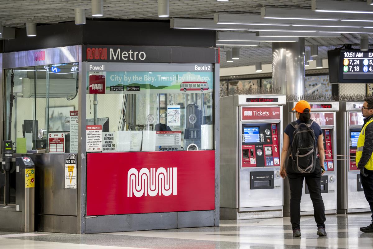 A photograph of a large red and white Muni Worm logo on the Muni station agent kiosk at Powell Station in San Francisco.