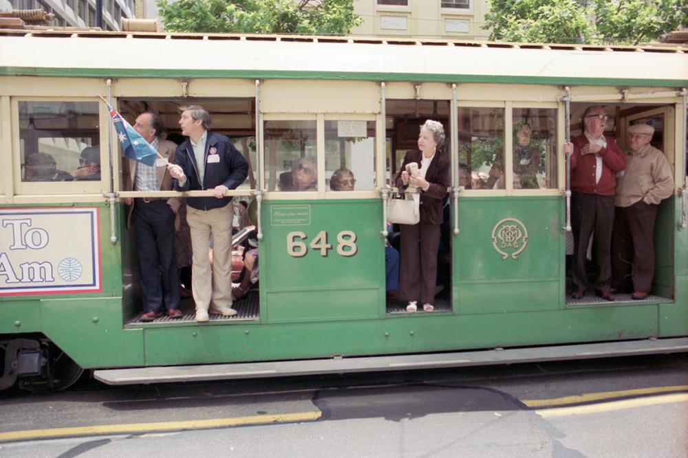 People ride a historic streetcar painted green and cream during the 1983 Trolley Festival.