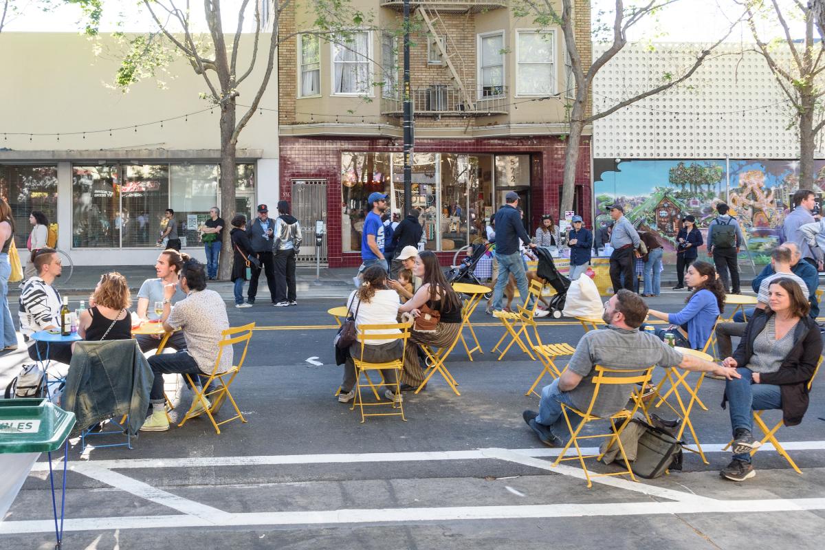 People sit in yellow folding chairs as others walk by at Valencia LIVE!.